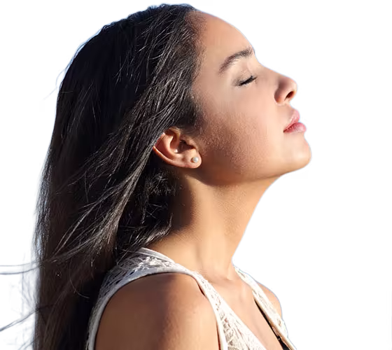 Mujer respirando profundo con los ojos cerrados, bienestar con oxigenación hiperbárica